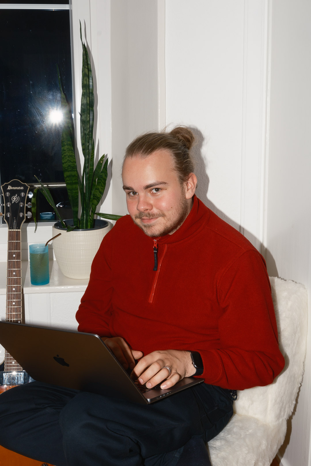 Portrait of person on computer, with red sweater